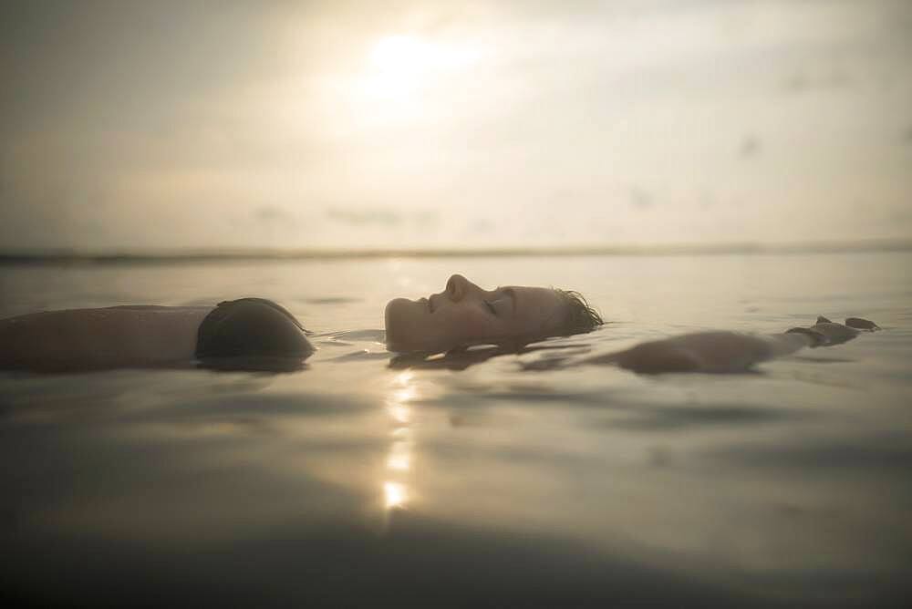 Caucasian woman floating in still lake