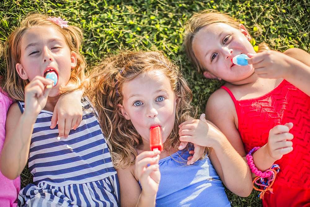 Girls eating flavored ice in grass