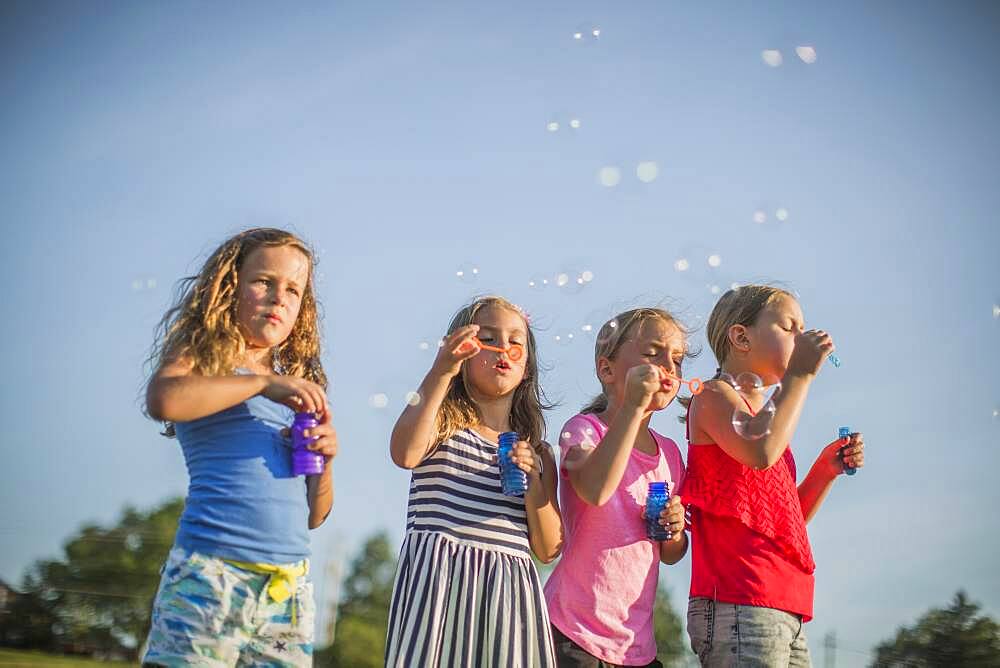 Girls blowing bubbles outdoors