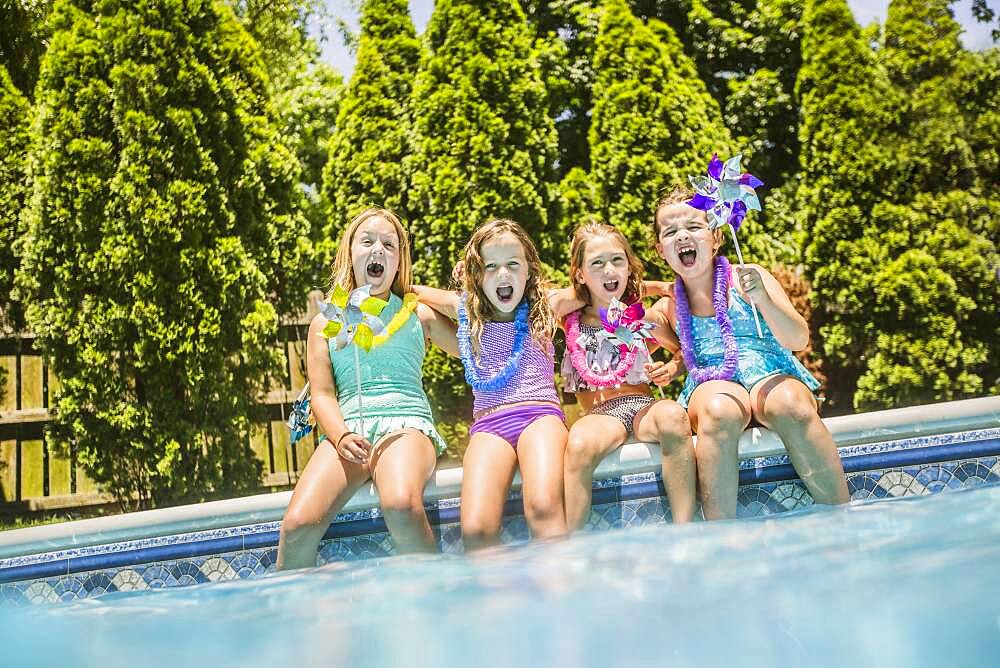 Caucasian girls cheering at swimming pool