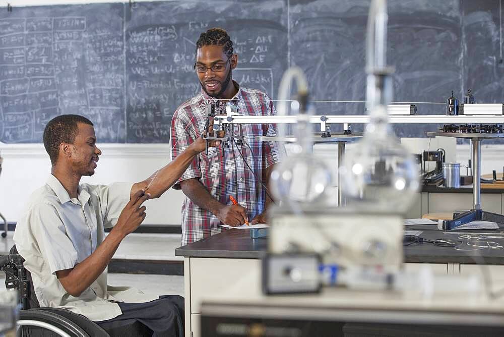 Paraplegic student working with classmate in science classroom