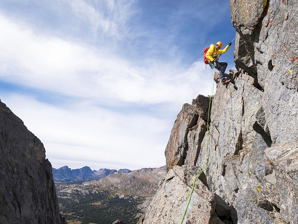 Caucasian climber rappelling on mountainside