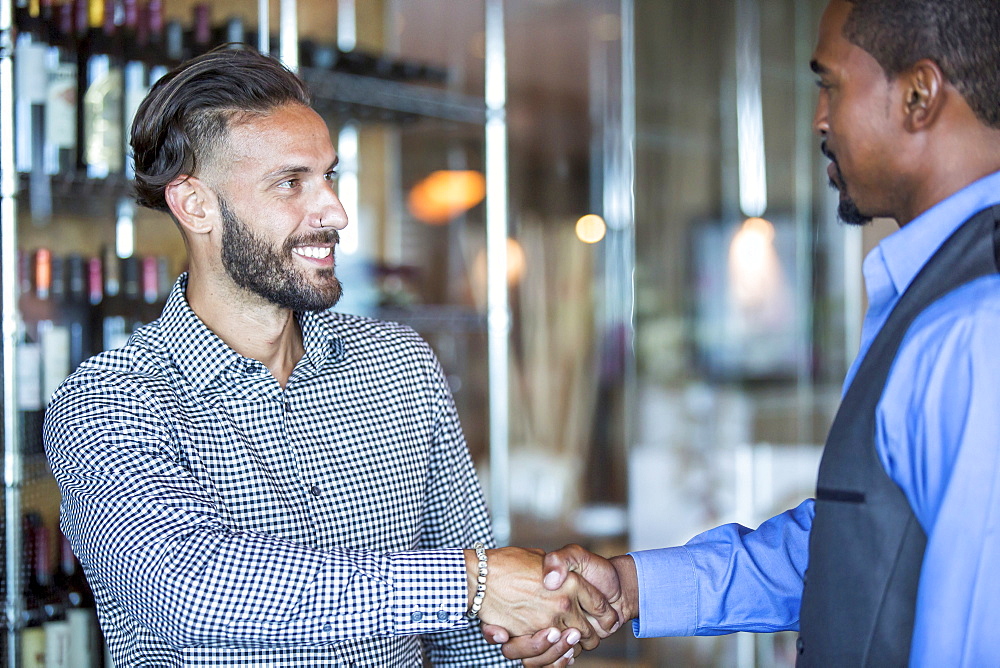 Businessmen shaking hands in restaurant