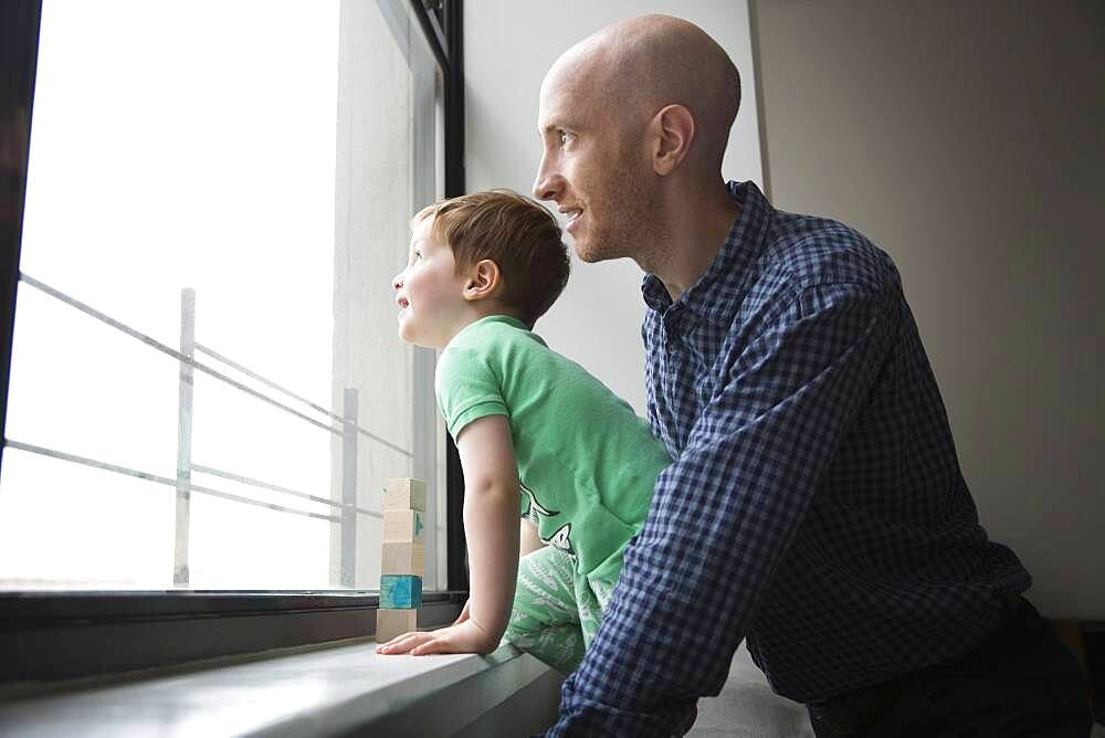 Father and son looking out window