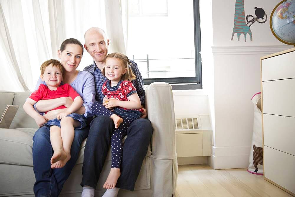 Family smiling on sofa