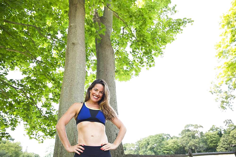 Mixed race woman standing under trees