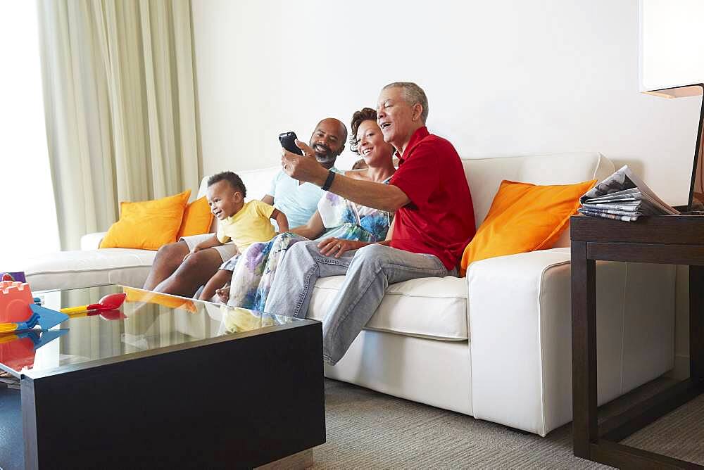 Multi-generation family taking selfie in living room