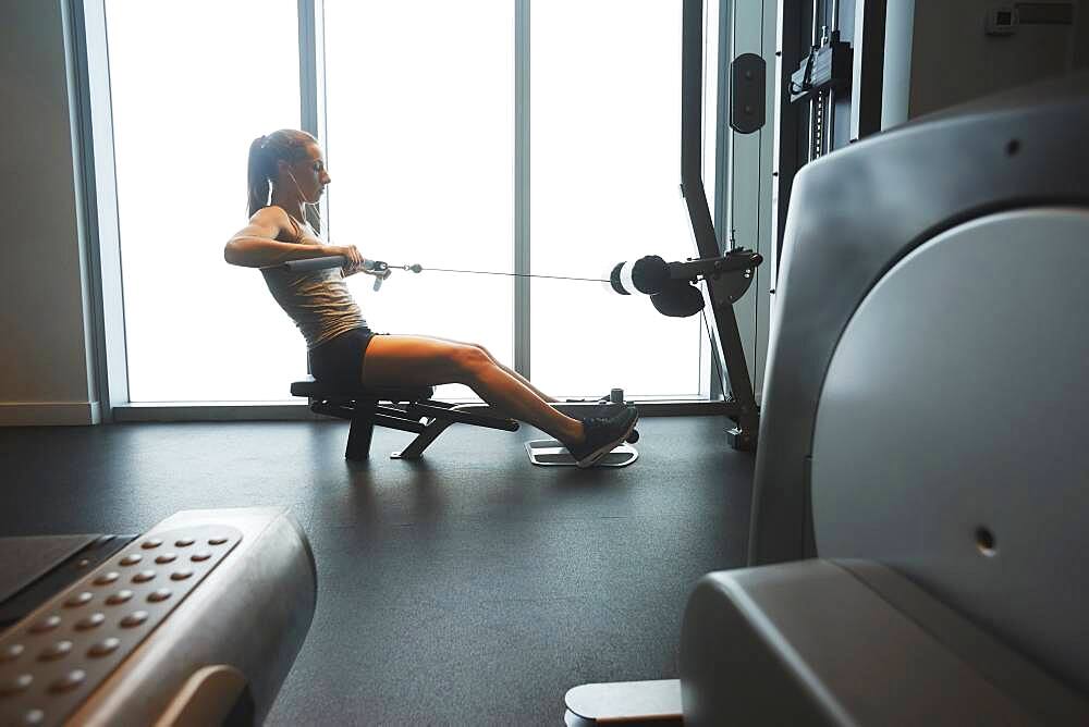 Woman using exercise machine in gym