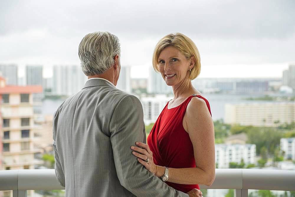 Caucasian couple hugging on balcony