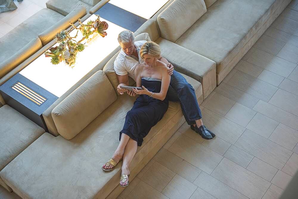 High angle view of Caucasian couple using digital tablet in hotel lobby