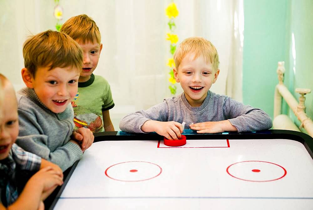 Caucasian boys playing air hockey