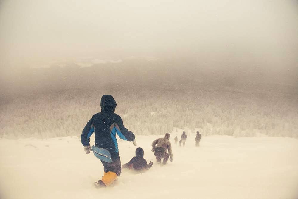 Caucasian hikers walking on snowy hill