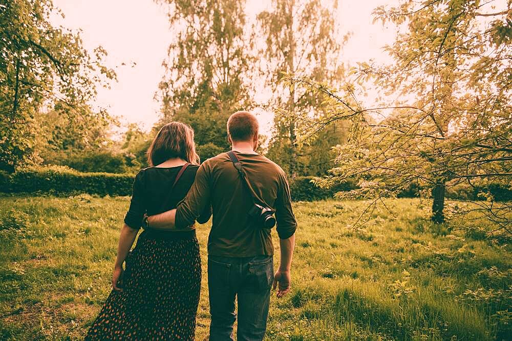 Caucasian couple walking in field