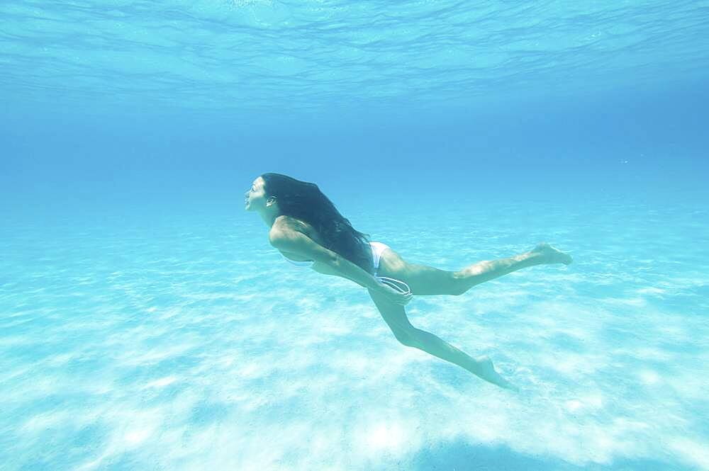 Underwater view of woman swimming in ocean