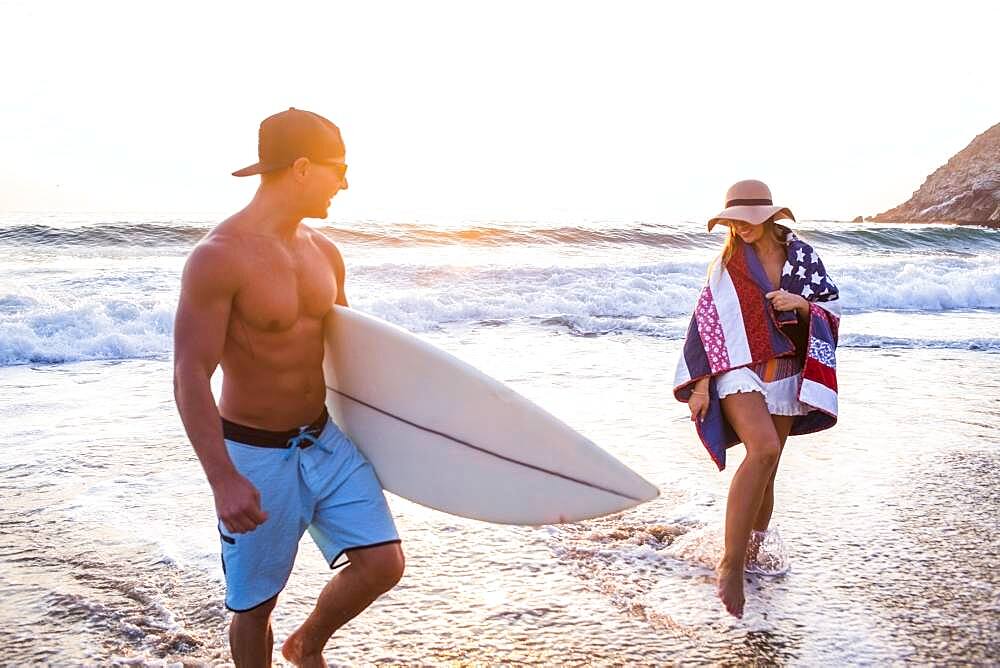 Caucasian couple walking on beach