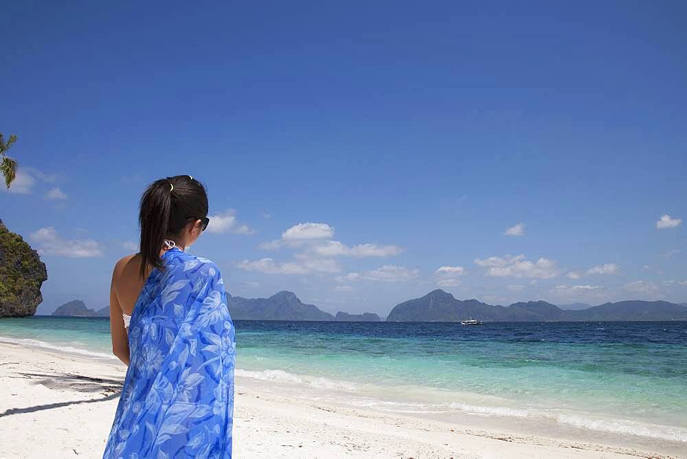 Asian woman walking on beach