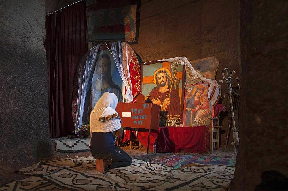 Black woman praying at shrine