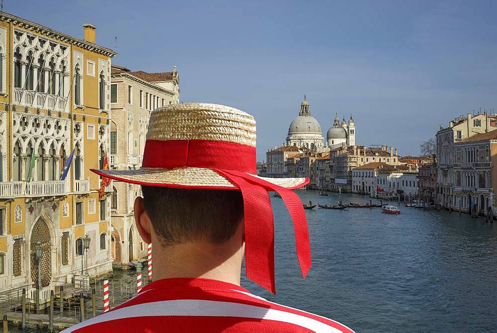 Caucasian gondolier admiring Venice cityscape, Veneto, Italy