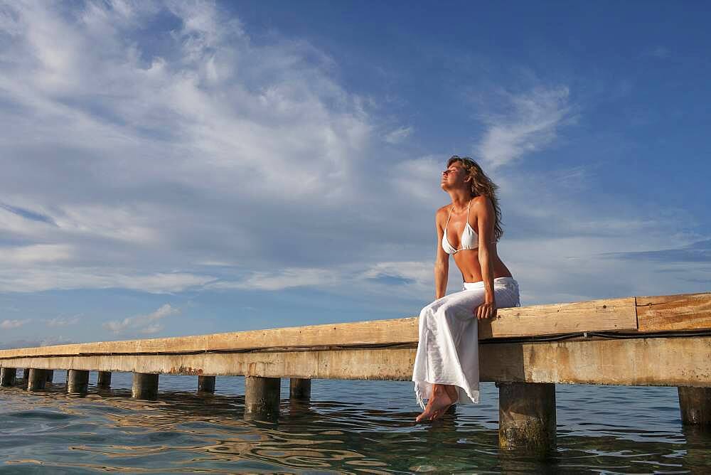 Caucasian woman sitting on wooden dock