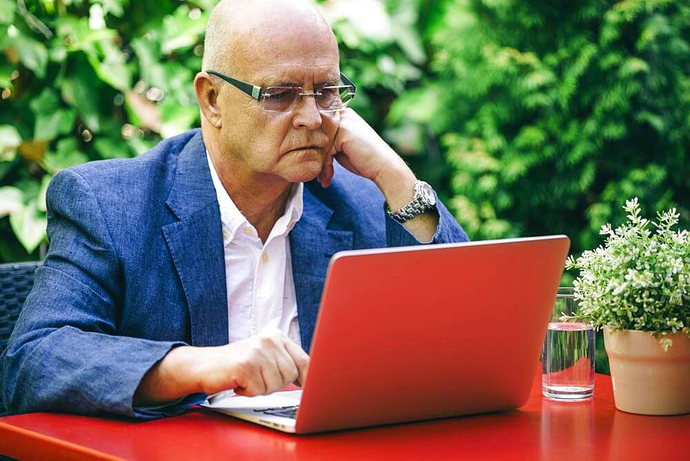 Hispanic businessman using laptop outdoors