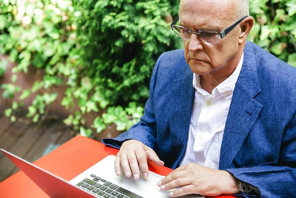 Hispanic businessman using laptop outdoors