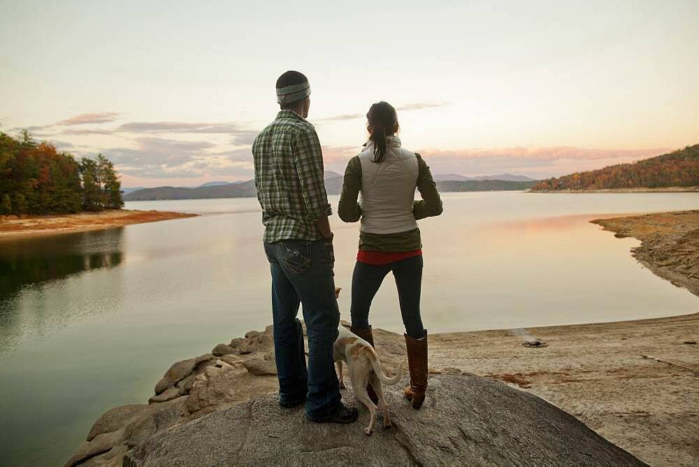 Couple and dog admiring remote lake