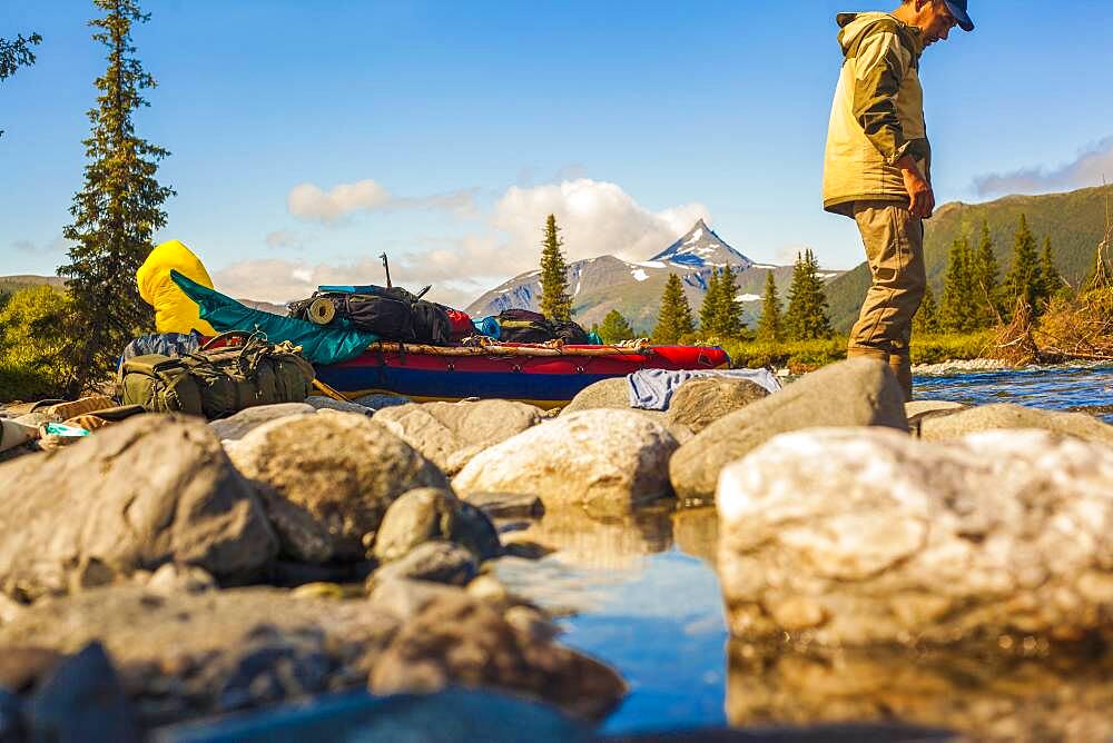 Mari hiker standing on rocks in remote river