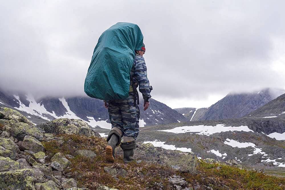 Mari backpacker walking on mountain path