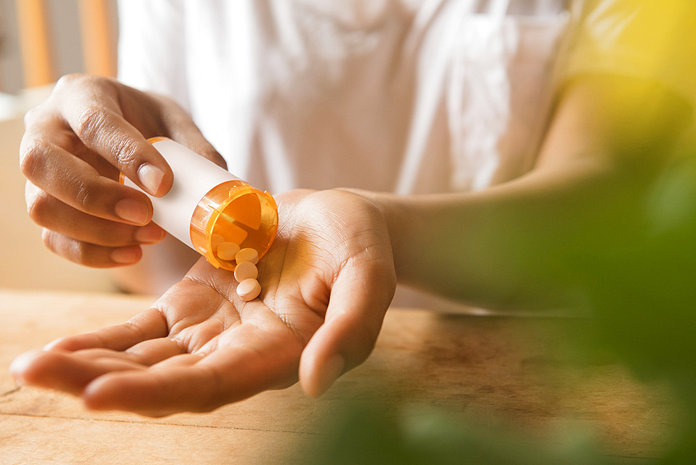 Hands of African American woman holding prescription medicine