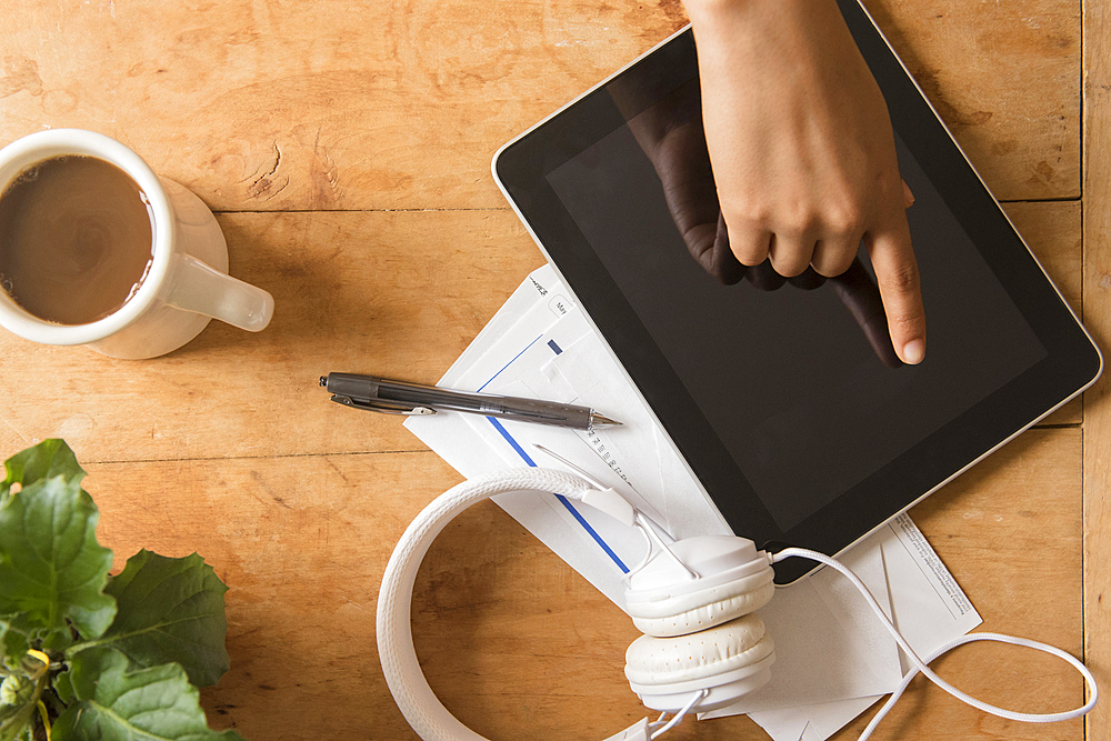 Finger of African American woman touching digital tablet