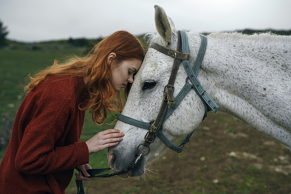 Caucasian woman petting horse