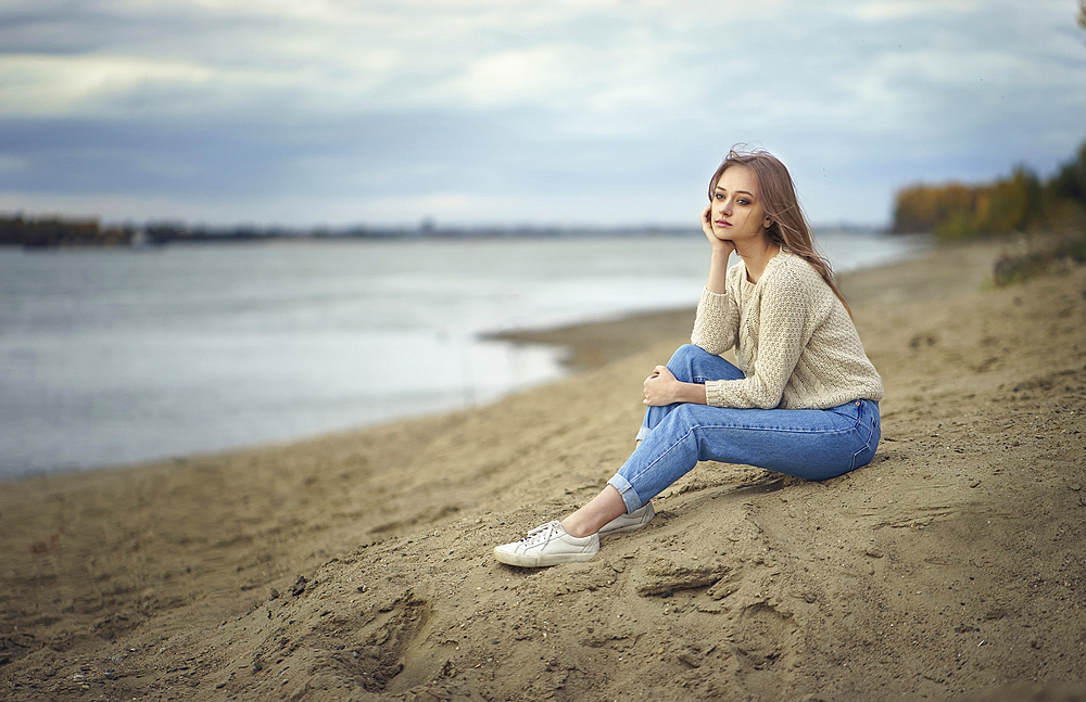 Pensive woman sitting on beach