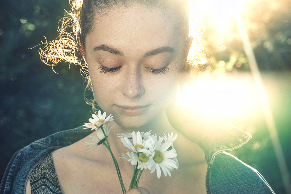 Caucasian woman smelling flowers