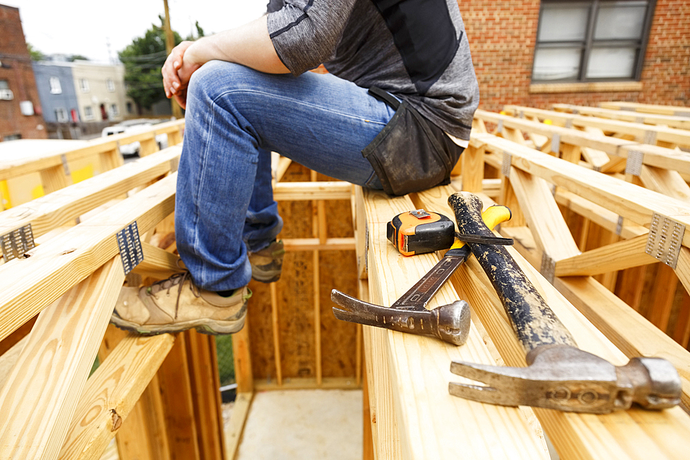 Caucasian man resting near hammer and tape measure