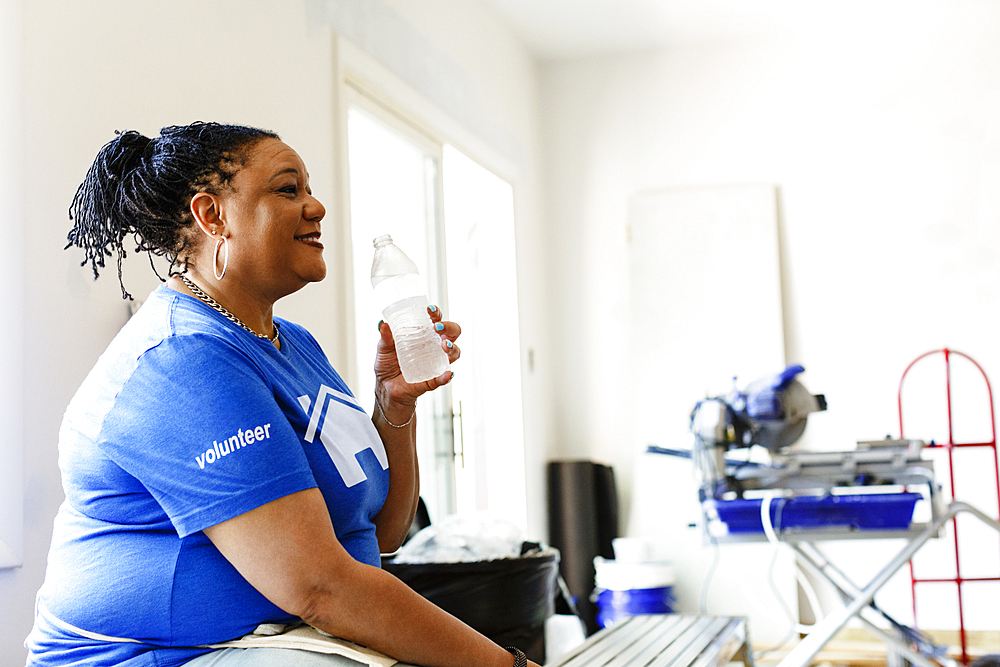 Black volunteer woman drinking water