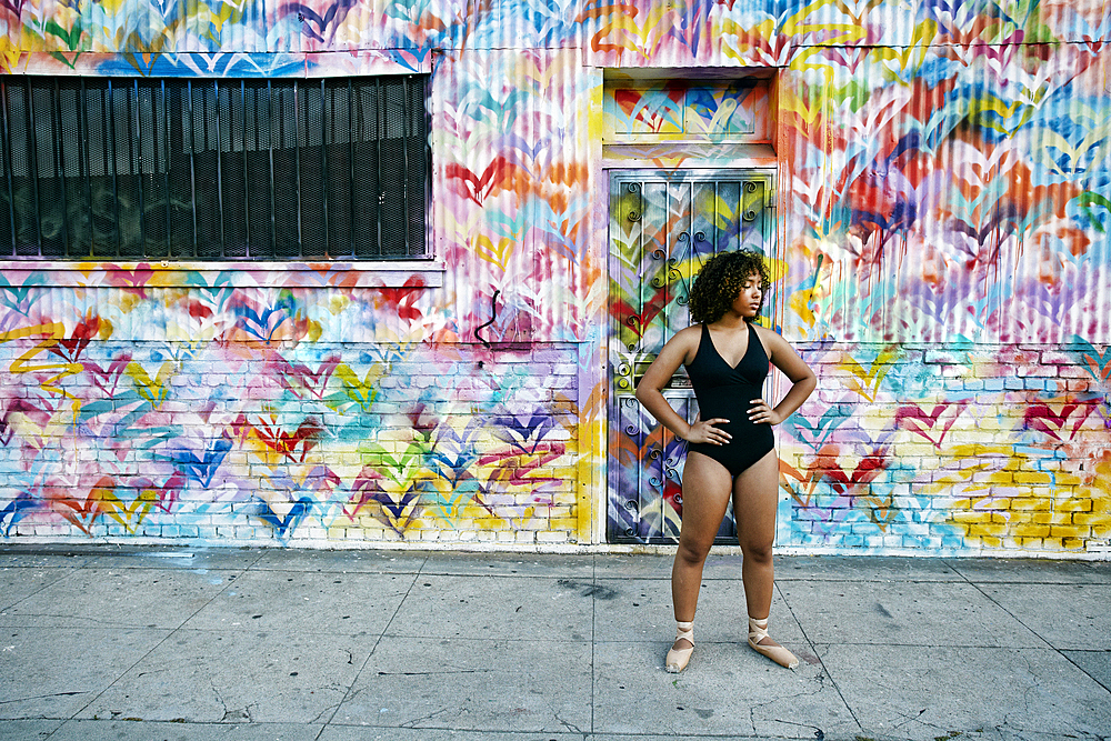 Mixed race ballet dancer resting on sidewalk