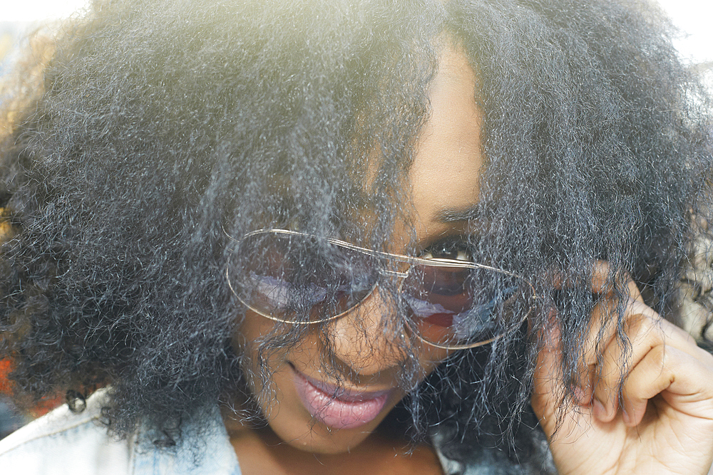 Close up of mixed race woman peering over sunglasses