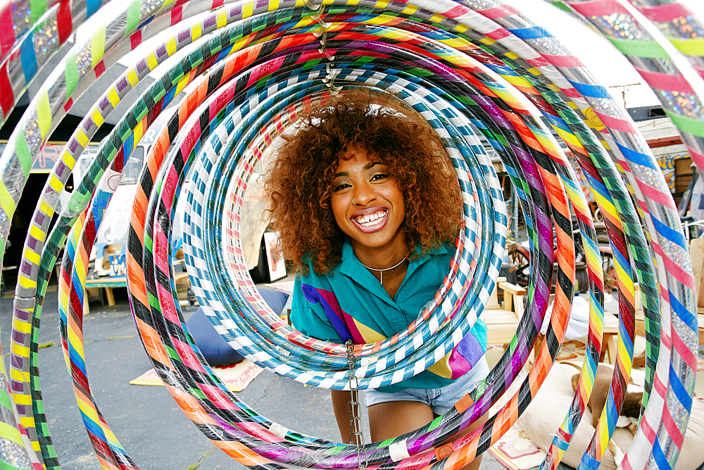 Portrait of smiling black woman behind hoops