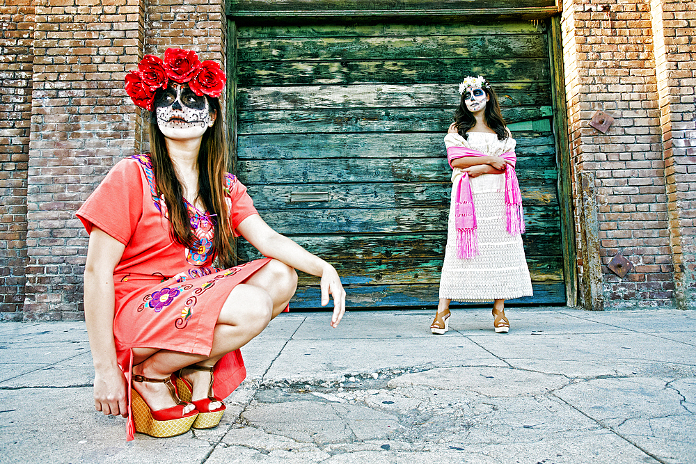 Women on sidewalk wearing skull face paint