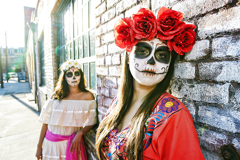 Women on sidewalk wearing skull face paint