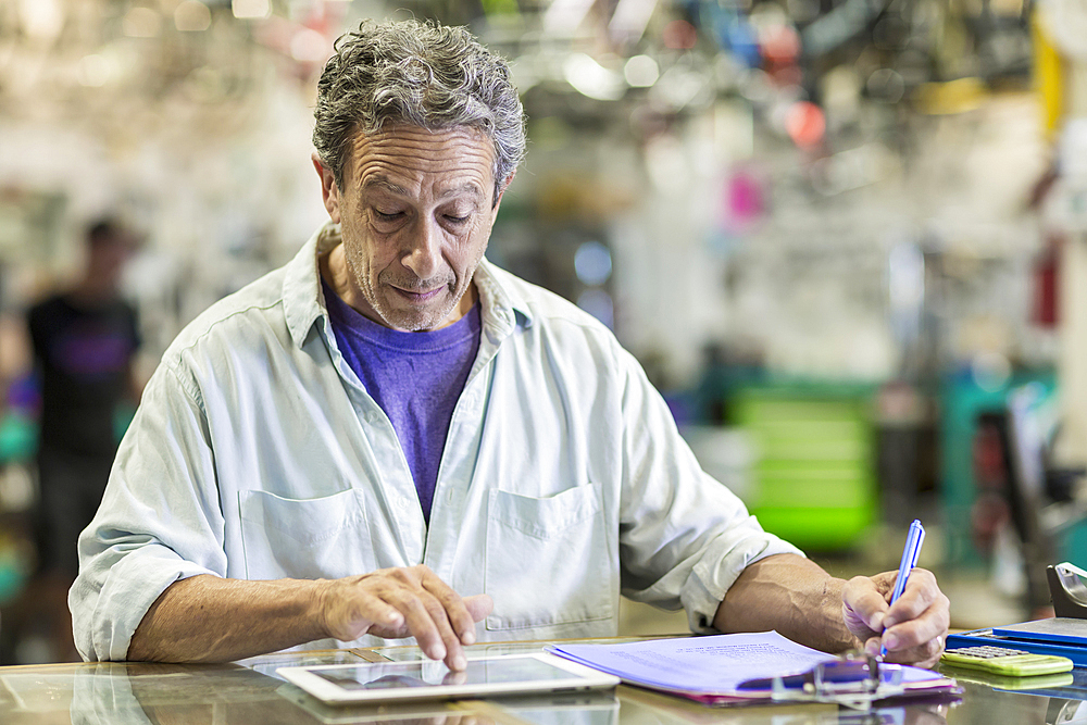 Caucasian man in bicycle shop using digital tablet