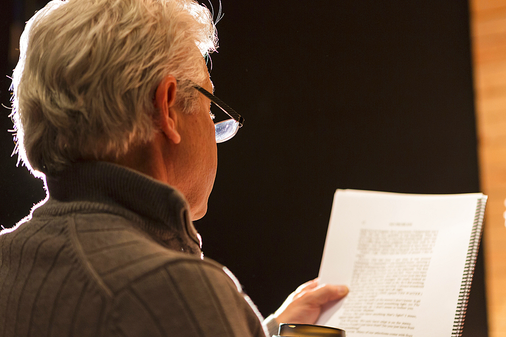 Hispanic man reading script in theater