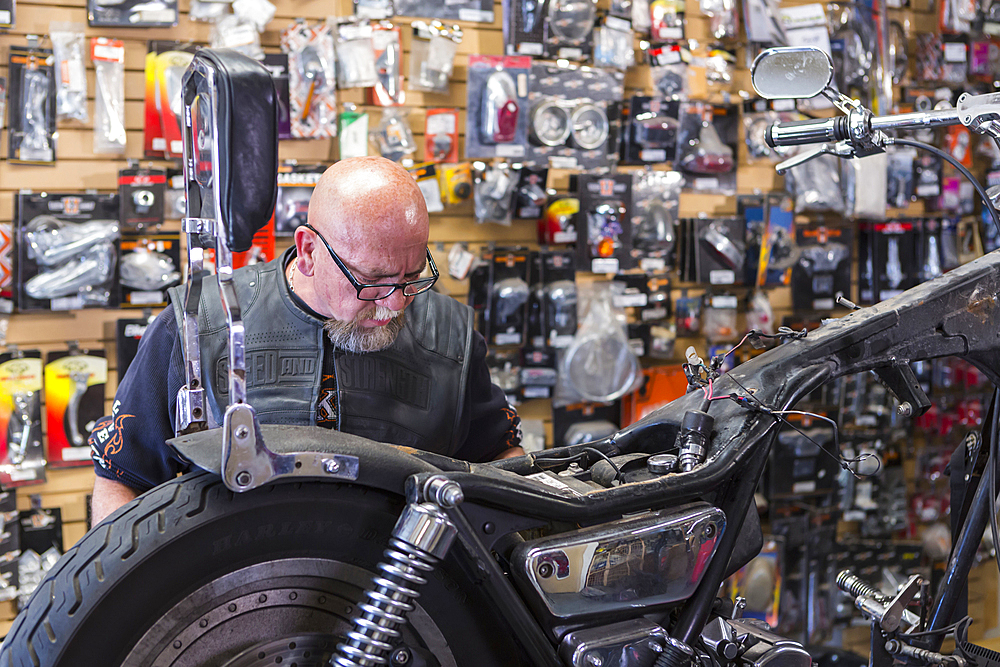 Caucasian man repairing motorcycle