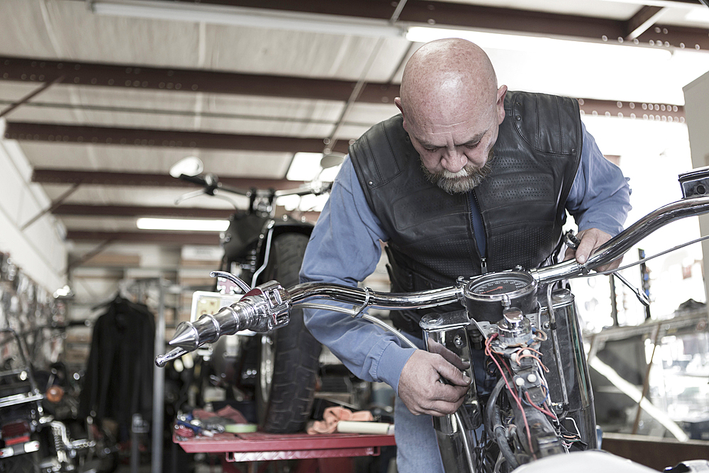 Caucasian man repairing motorcycle