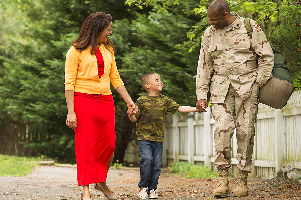 African American woman and boy walking with soldier