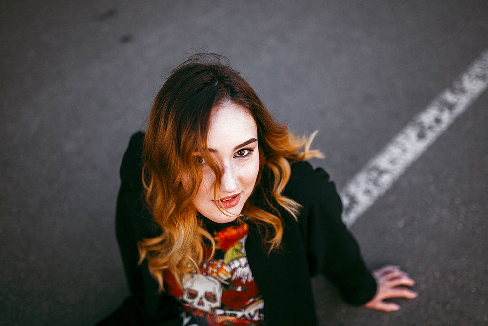 Caucasian woman sitting on street