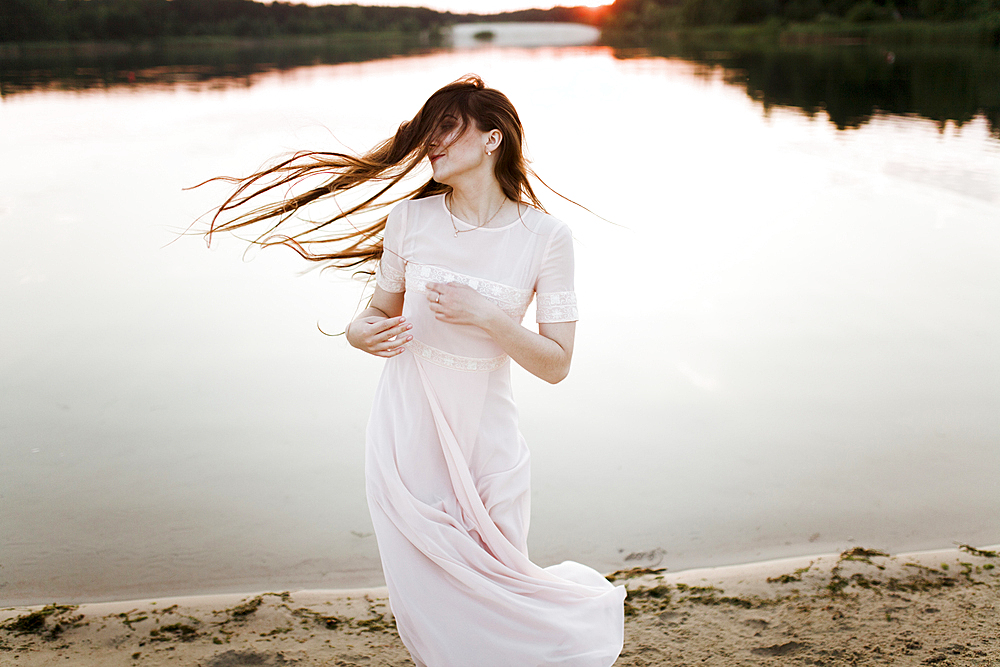 Caucasian woman tossing hair on beach