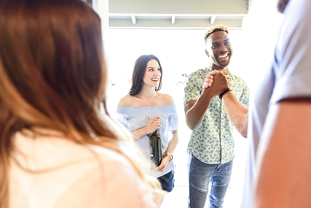 Man greeting friends in doorway