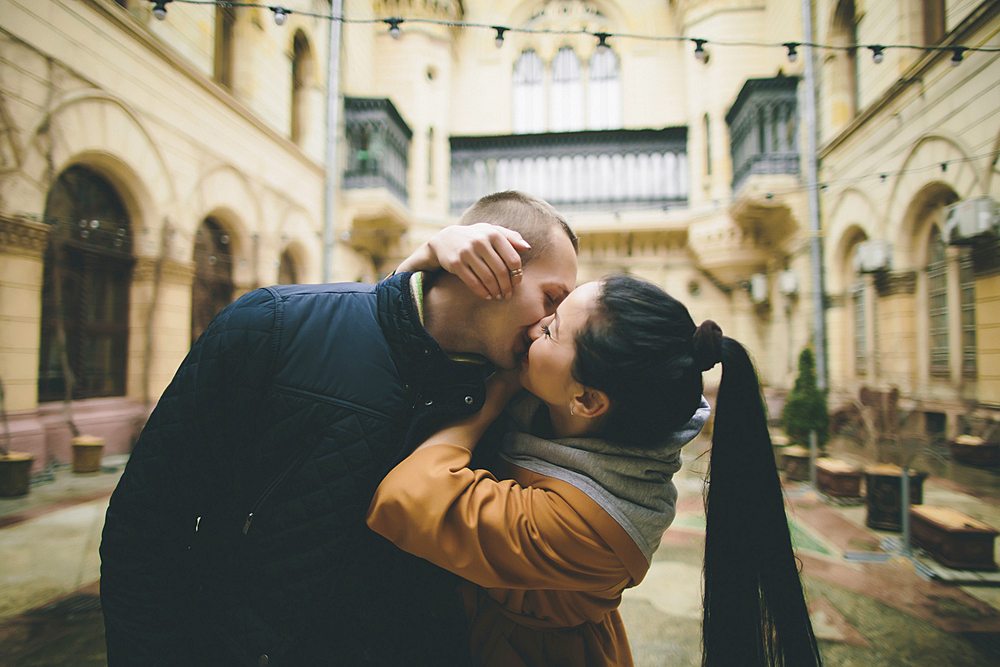 Caucasian couple kissing in courtyard