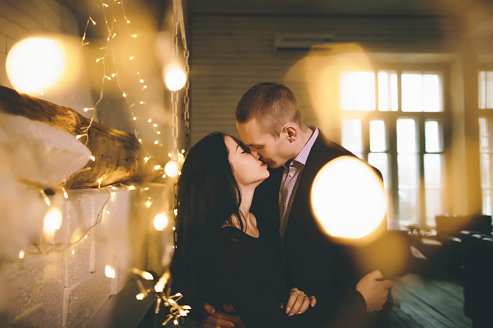 Caucasian couple kissing near wall